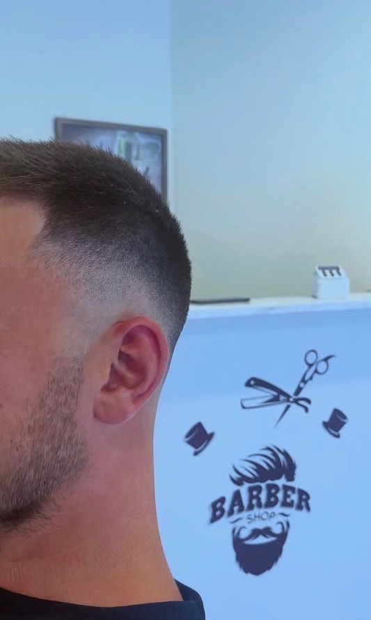 Skin fade och skägg med rakad delning i profil